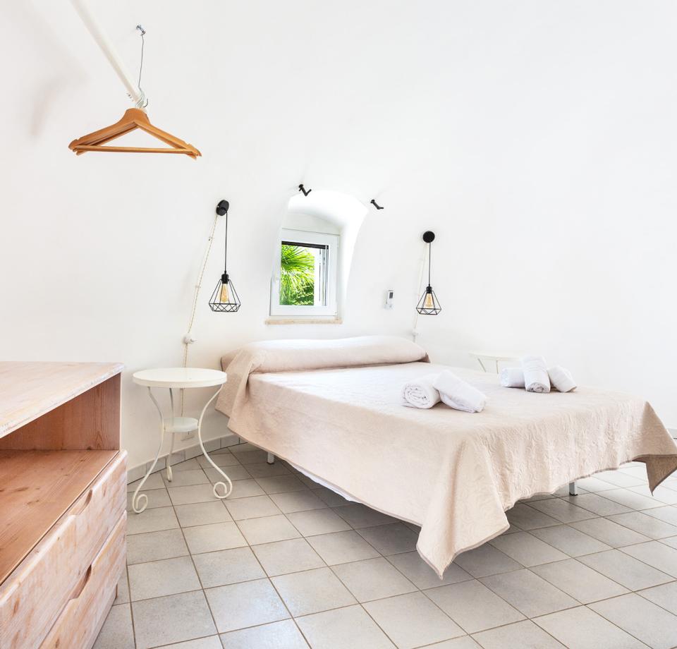 Bright bedroom with a double bed and minimalist decor.